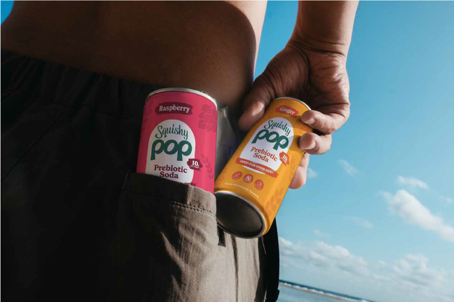 Two cans of Squishy Pop held in back pockets at the beach